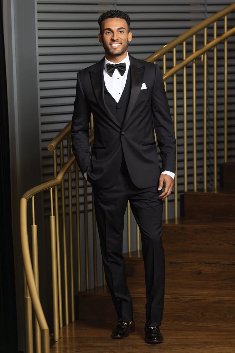 Man wearing the Michael Kors Milan Performance Stretch Tuxedo coat with matching slim fit performance fit pants, vest and a tear drop bow tie.