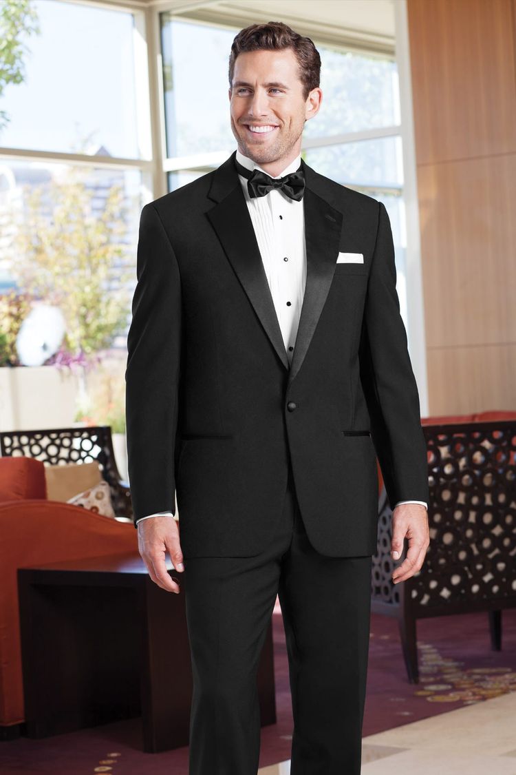 man wearing classic black notch tuxedo coat with pleated, wing collared shirt, black bow tie, and a white pocket square