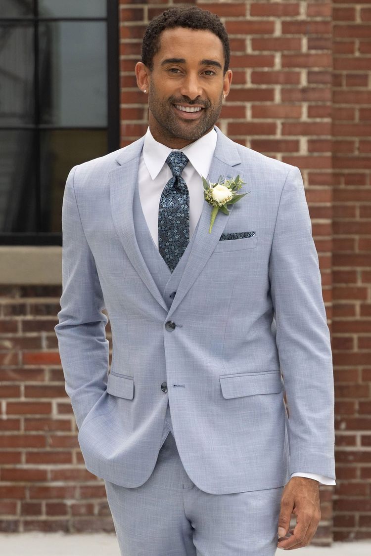 man wearing oxford blue suit with matching vest, white shirt, and slate blue floral windsor tie