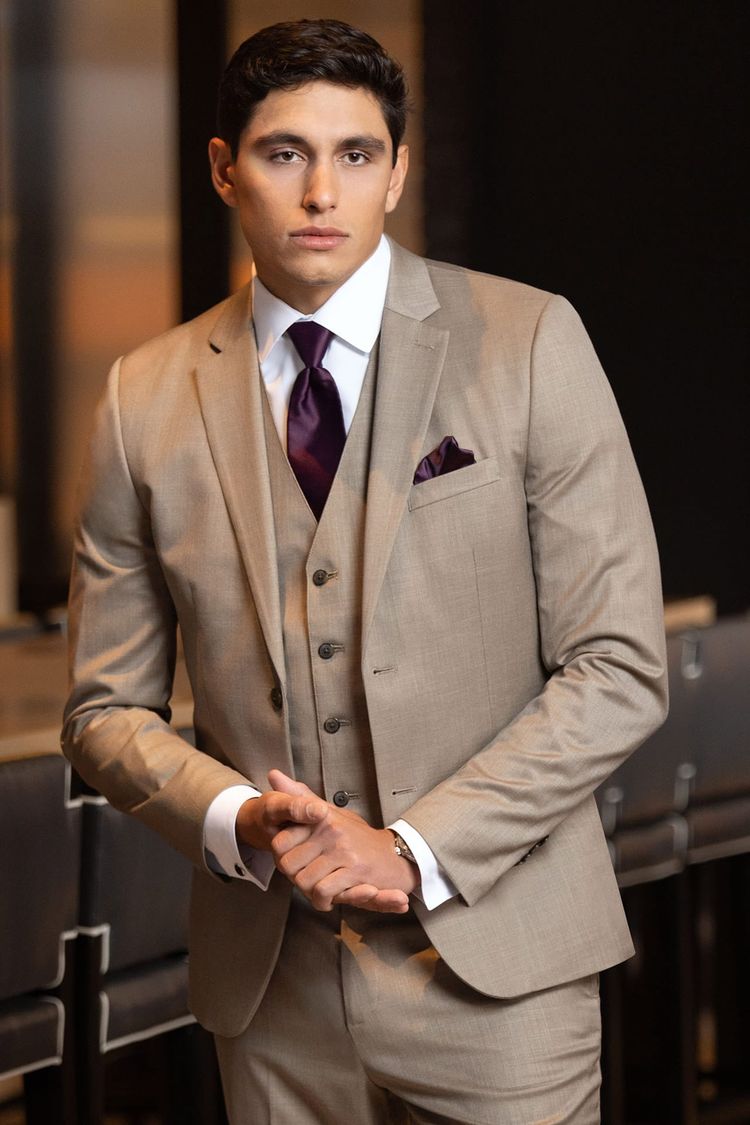 man wearing wheat suit with matching vest, white shirt, and solid plum windsor tie