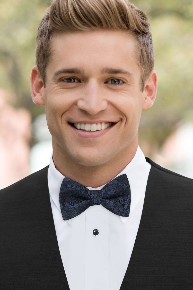 Guy wearing a floral bow tie navy with a black vest