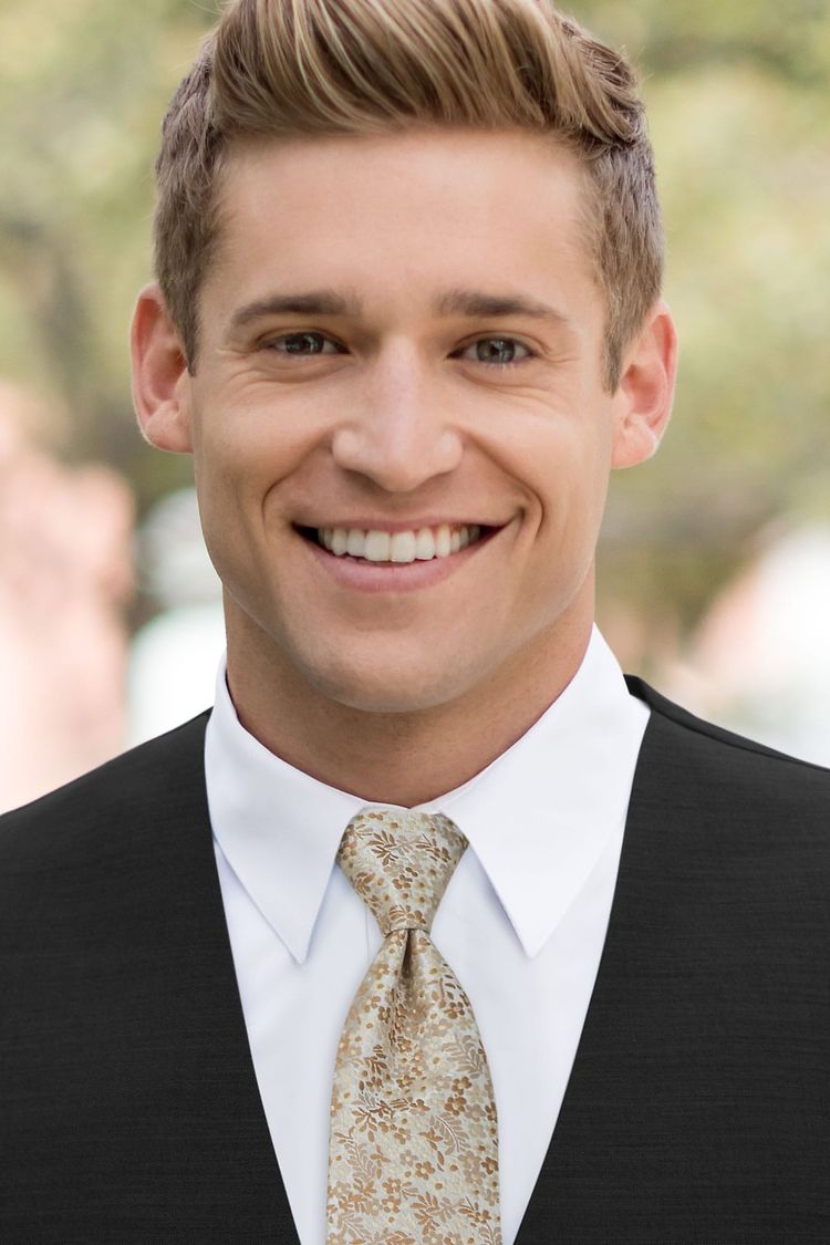 Man wearing a floral windsor tie gold with a black vest