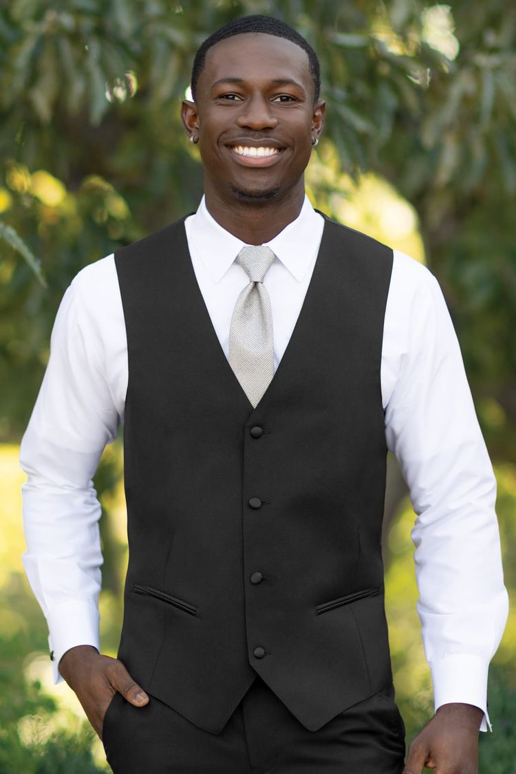 man wearing black matching wool vest in performance stretch with white shirt and sage green tie