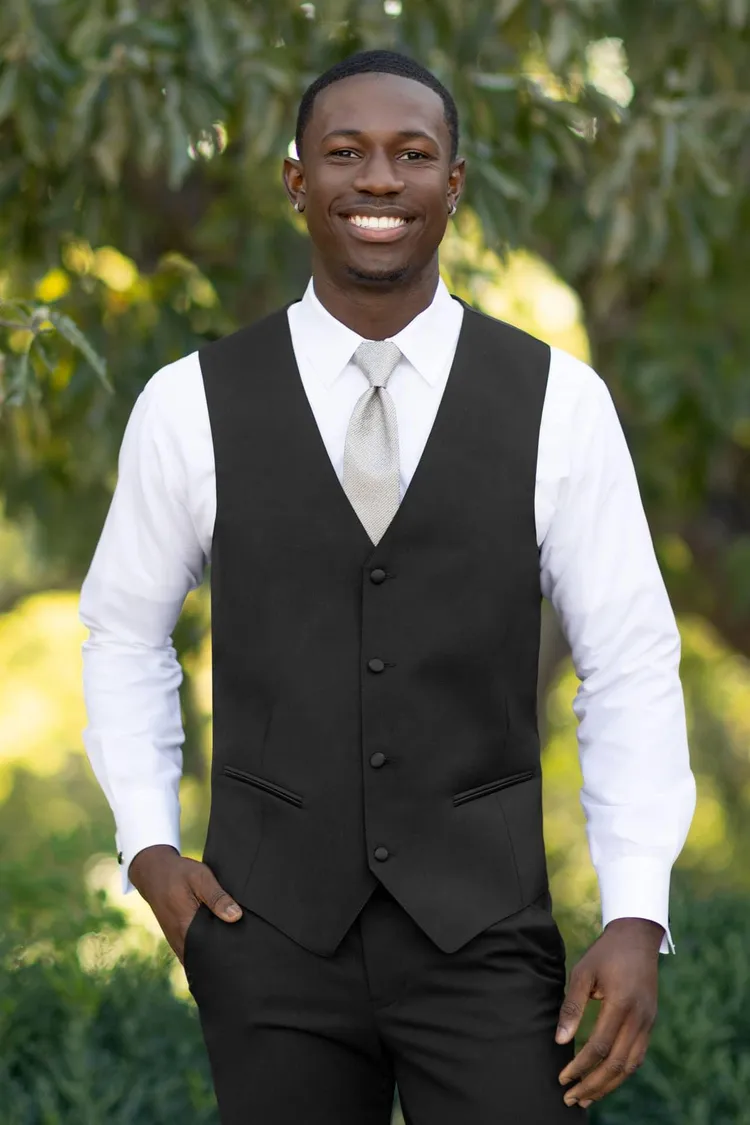 man wearing black matching wool vest in performance stretch with white shirt and sage green tie