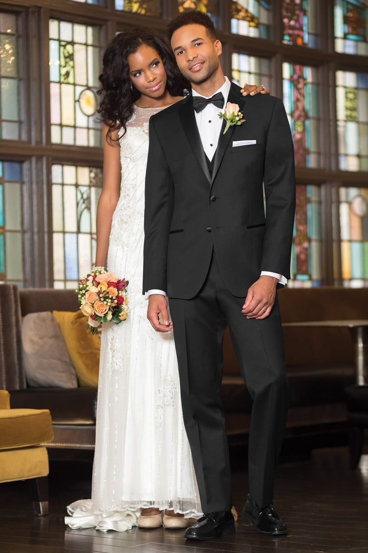man wearing super 120's slim fit tuxedo coat with matching pants, white laydown collar, black bow tie, and white pocket square