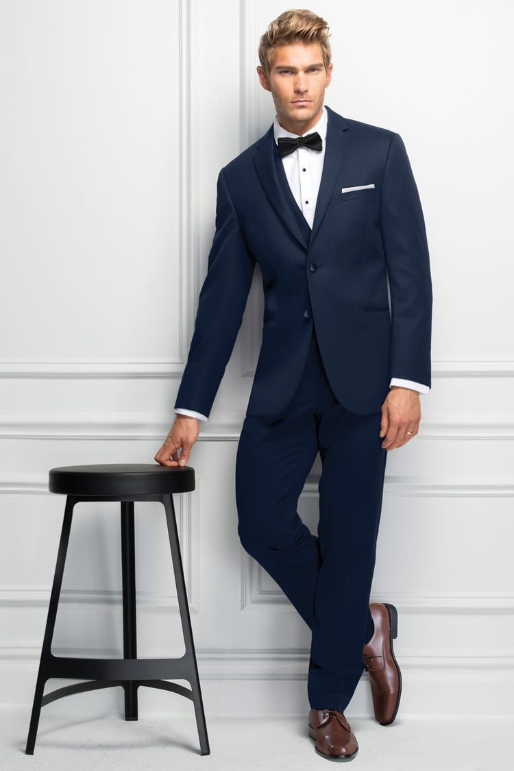 Man leaning on a stool in a Wedding Suit Navy Michael Kors Sterling with matching Fullback Vest and Black Bow Tie