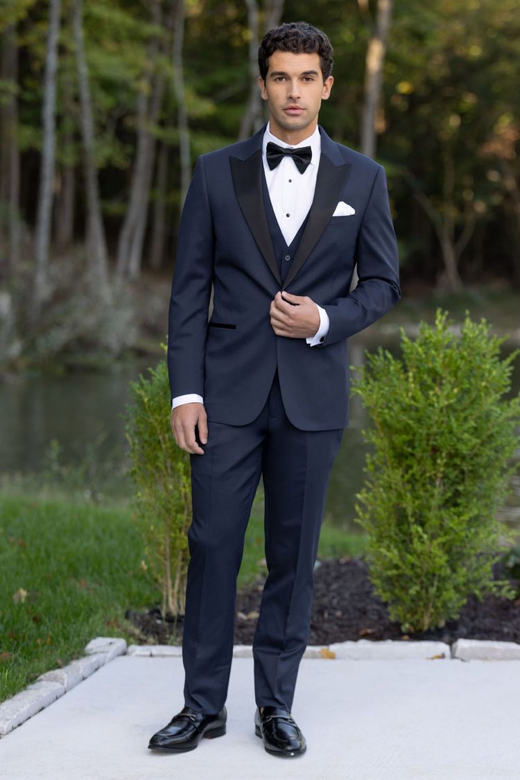 man wearing Navy Performance Stretch Suit, white shirt, tear drop bow tie and slip on shoes